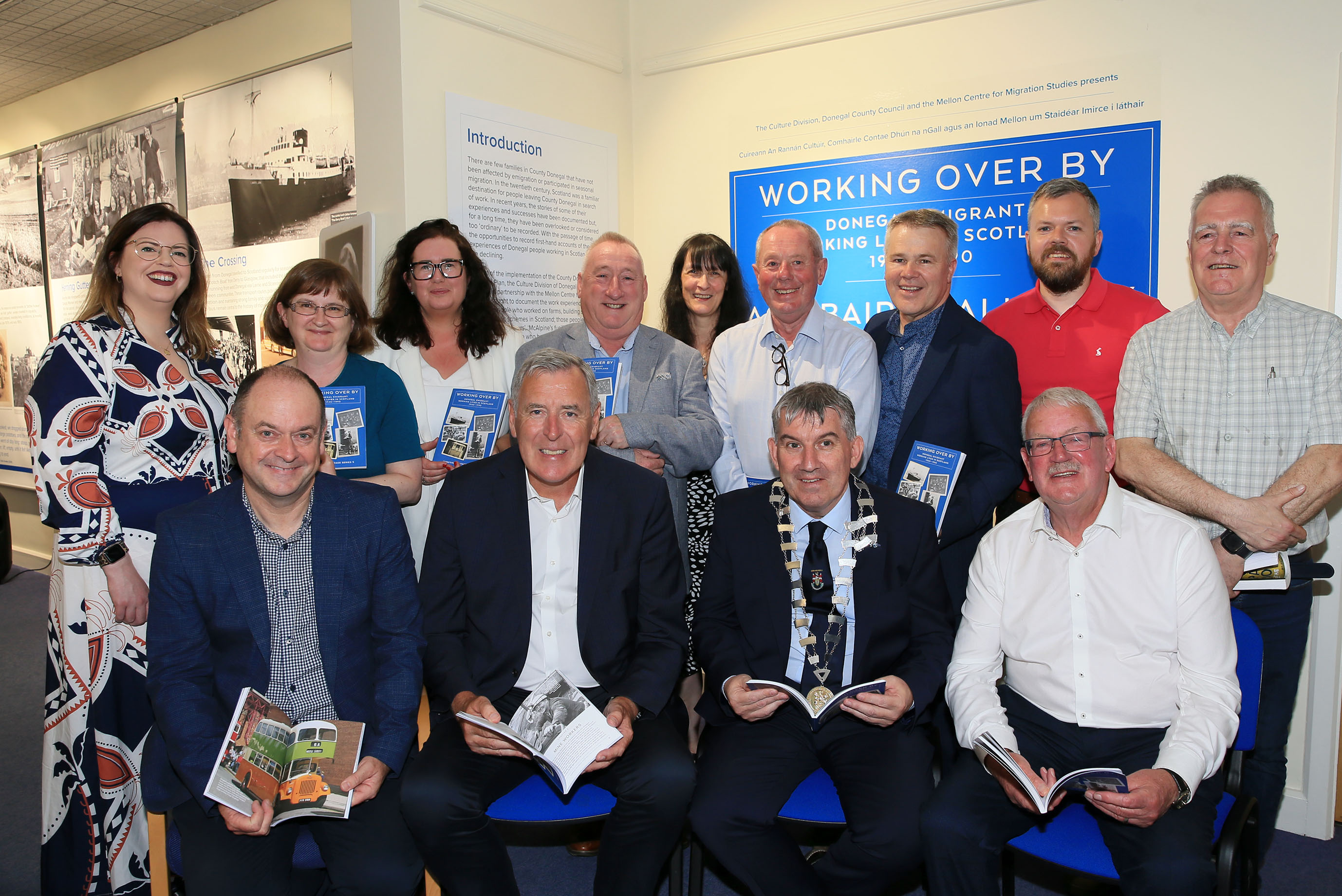 Ag seoladh an taispeántais ‘Ag Obair Thall’ (chun tosaigh ó chlé go deas): Patsy Lafferty, Packie Bonner, an Clr Paul Canning & an Clr Donal Coyle agus (ar chúl ó chlé go deas): Máire Ní Fhearraigh, an Dr. Niamh Brennan, Caroline Carr, an Dr. Patrick Fitzgerald, Judith McCarthy, an Dr. Liam Campbell, an Dr. Joseph Gallagher, Eoin Leonard & an Clr Jimmy Kavanagh. Grianghraf: Declan Doherty