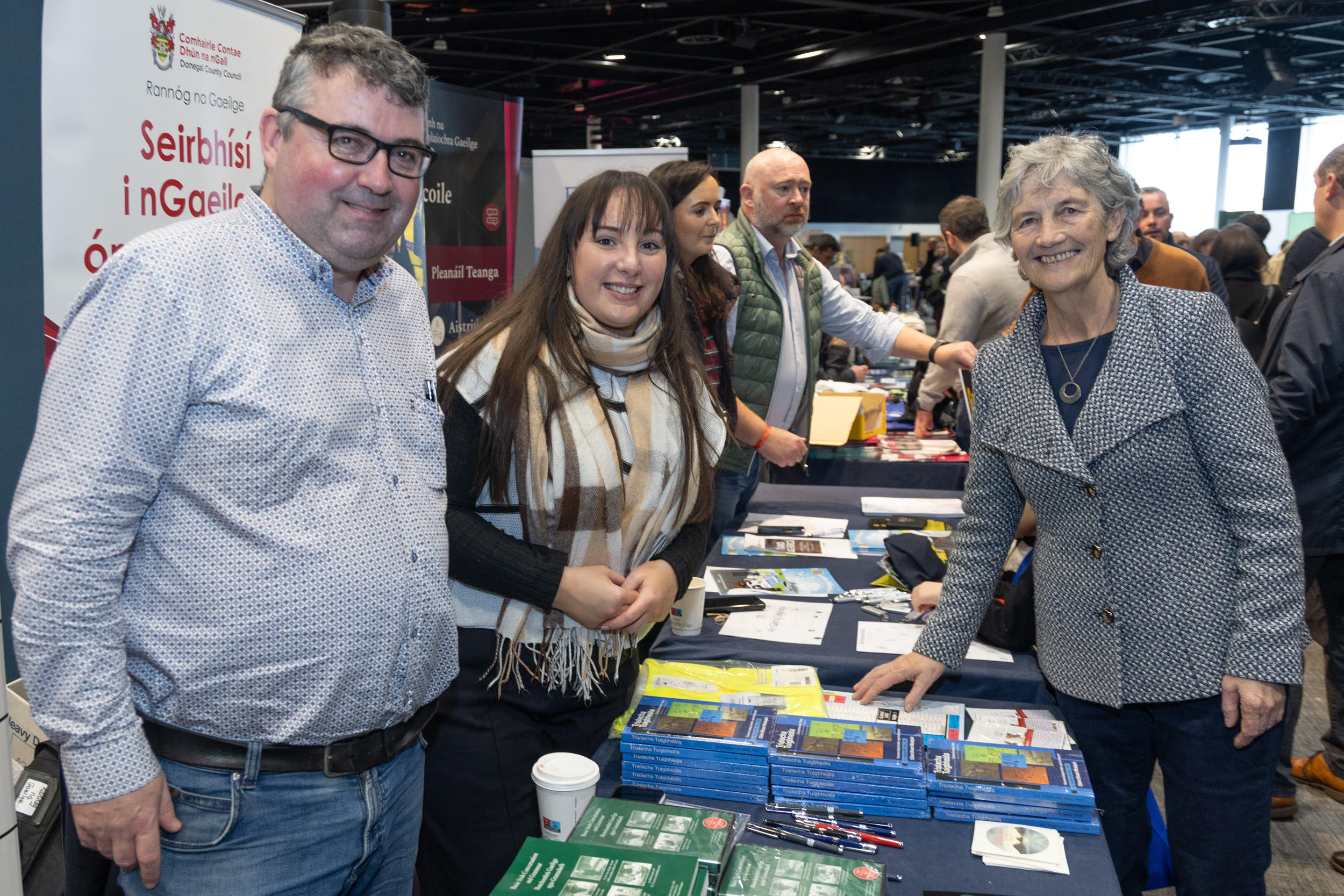 1.	Paddy Doherty (Bainisteoir Réigiúnach sa Rannóg Pobail agus Fiontraíochta) agus Clíona Ní Ghallachóir (Rannóg na Gaeilge) leis an Uachtarán nuathofa Catherine Connolly ag seastán na Comhairle. Grianghraf: Seán Ó Mainnín